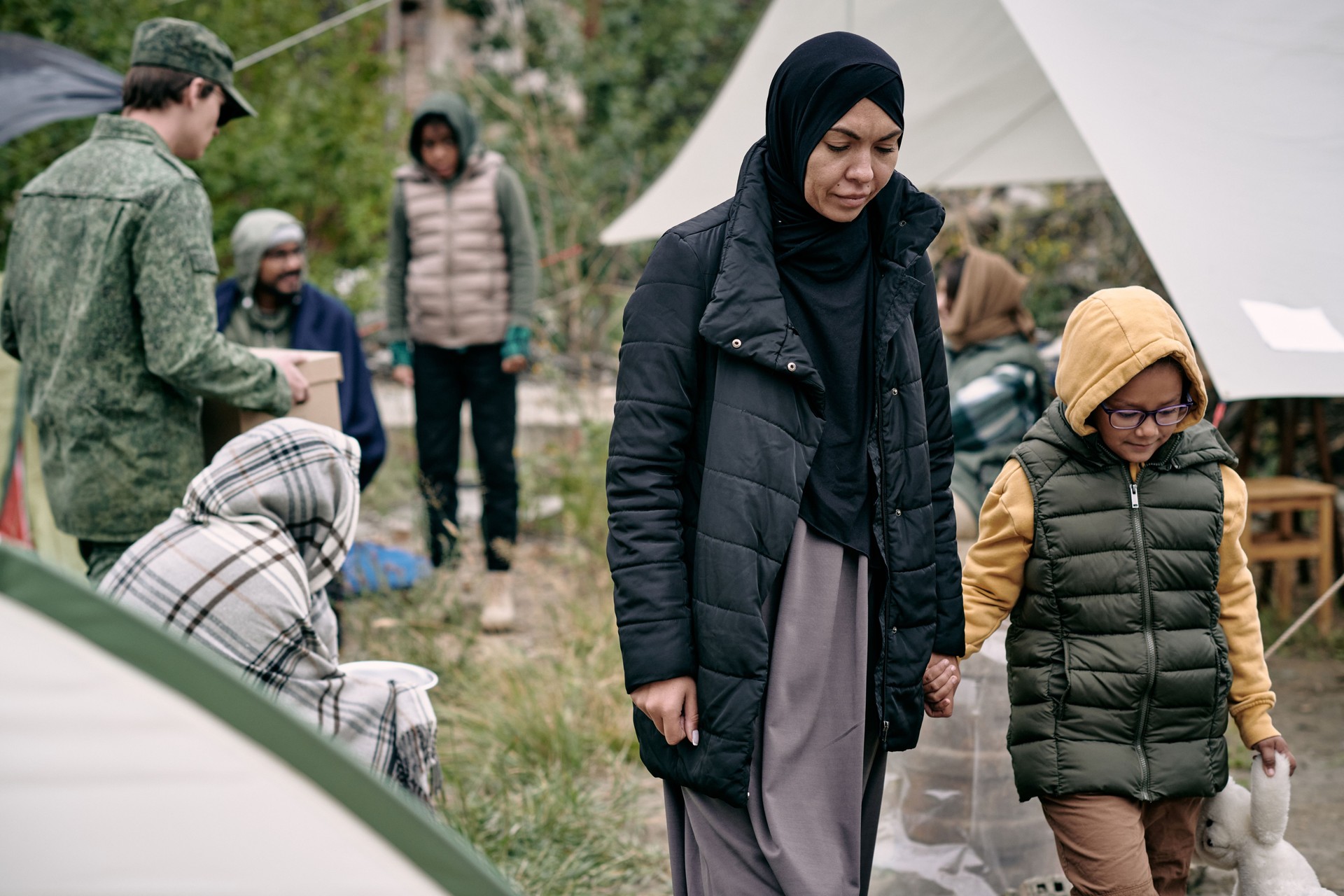 Young Muslim female holding her daughter by hand